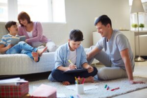 A family enjoys playtime on a soft rug, surrounded by colorful toys