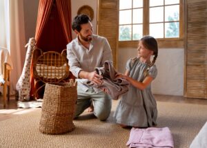 A child hands a stack of folded towels to an adult