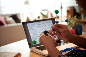 A person constructs a molecular model using colored balls and sticks